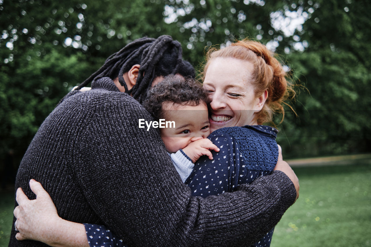 Happy family embracing son at park