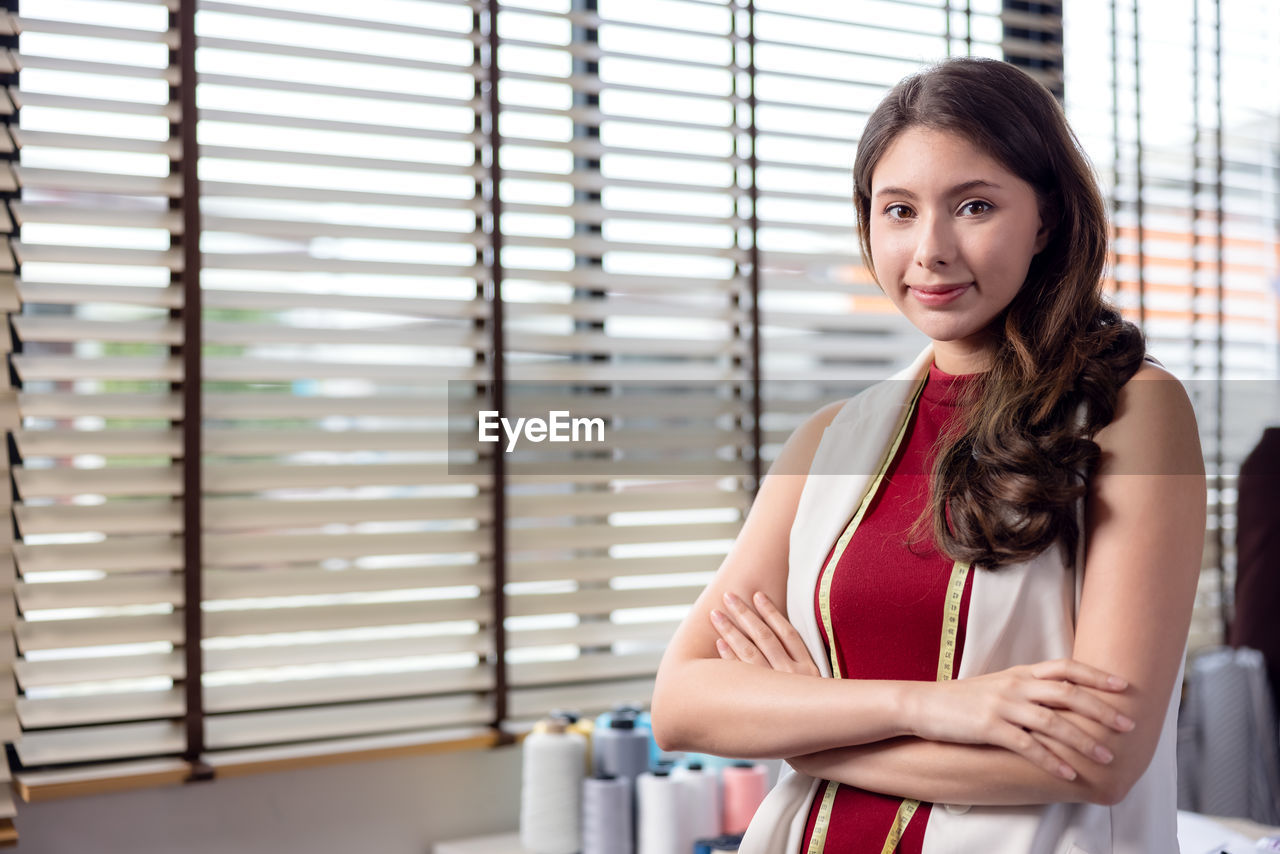 At work, a portrait of a smiling fashion designer and a creative woman is taken.