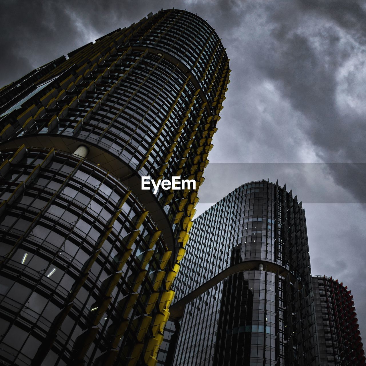 Low angle view of modern buildings against dramatic sky