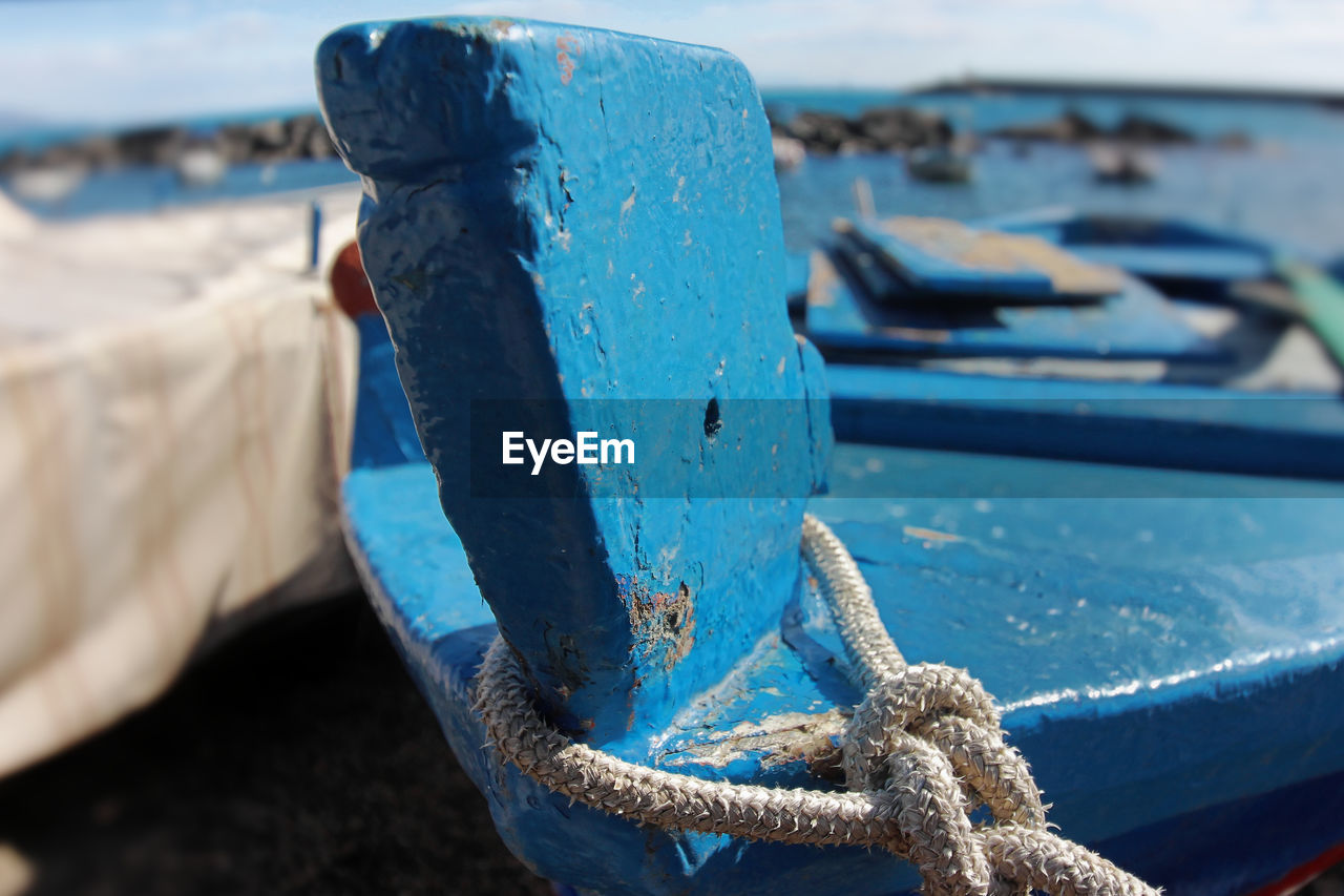 CLOSE-UP OF ROPE TIED ON METAL