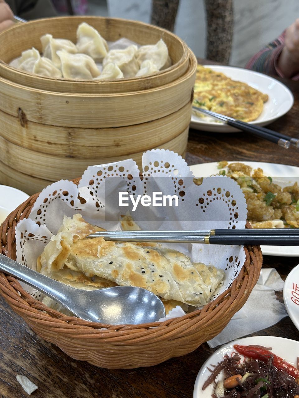 food and drink, food, freshness, dim sum, basket, dish, chinese dumpling, dumpling, asian food, container, healthy eating, chinese food, wellbeing, table, hand, meal, cuisine, plate, steamed, business, bowl, variation, still life