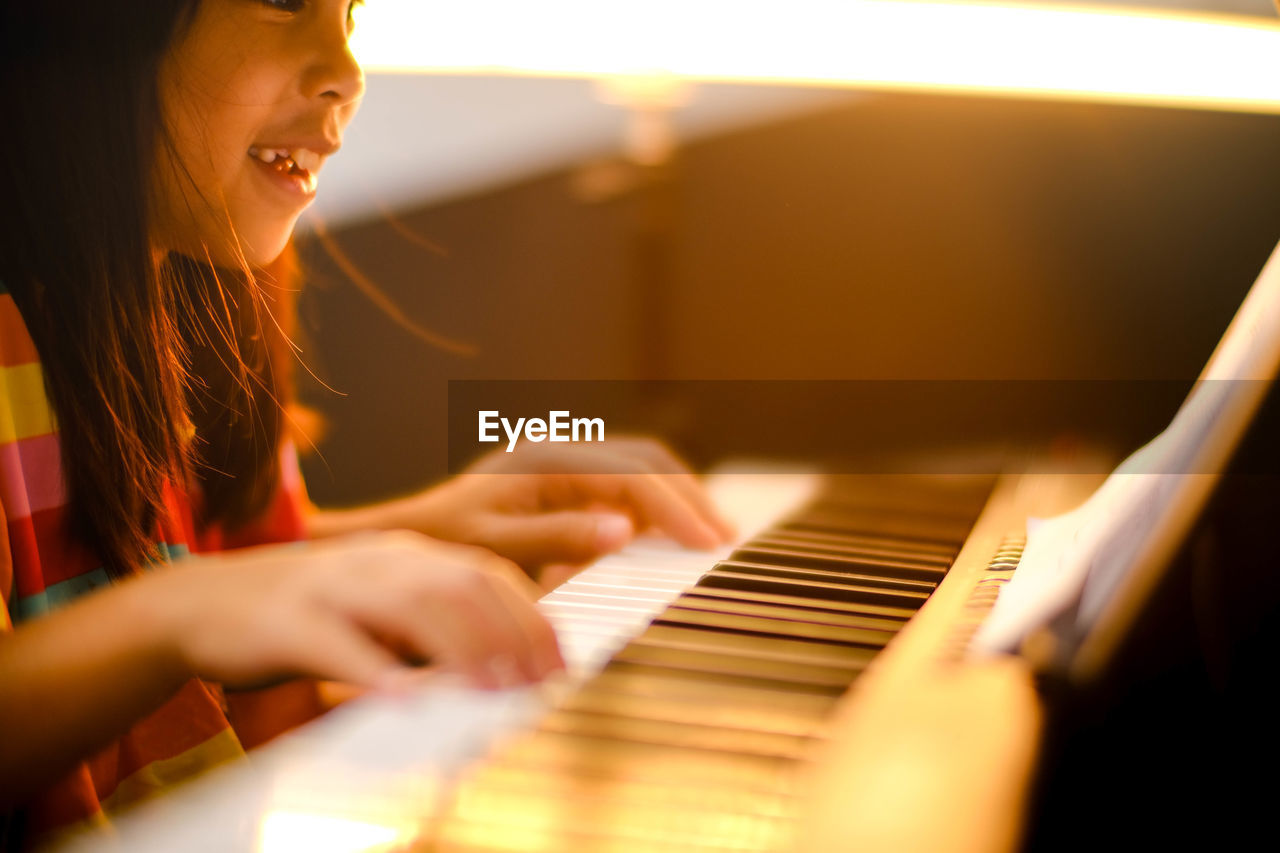 midsection of woman playing piano at home