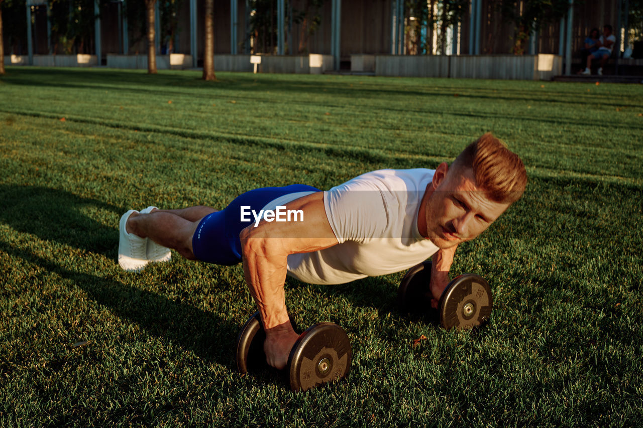 full length of man exercising on field