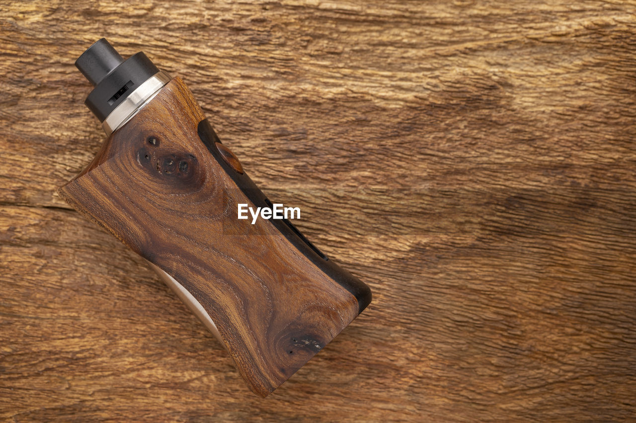 Rebuildable dripping atomizer with stabilized wood  box mods on rustic natural wood, vape stuff