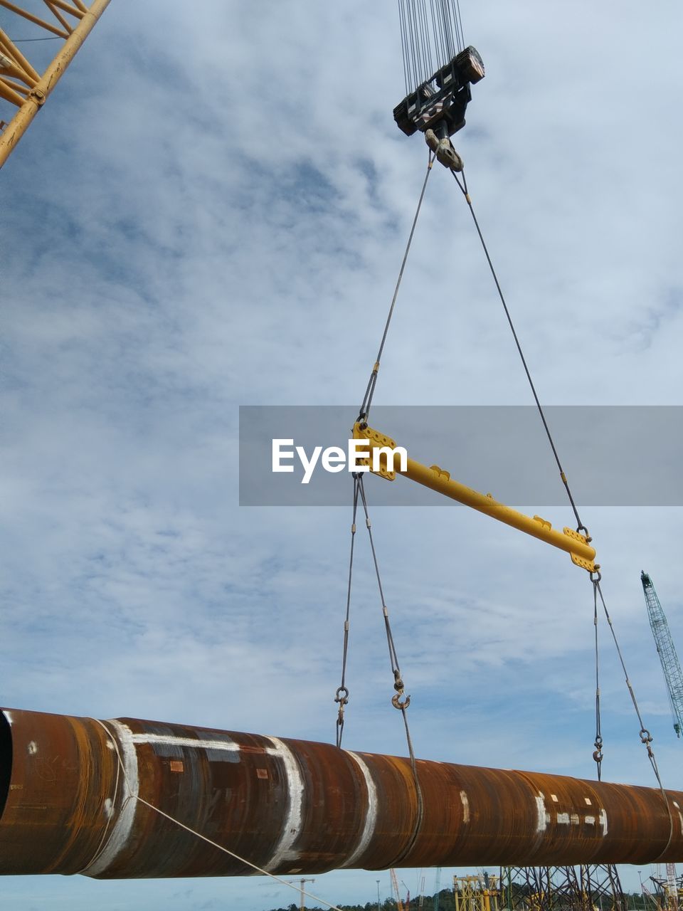 Low angle view of crane against sky