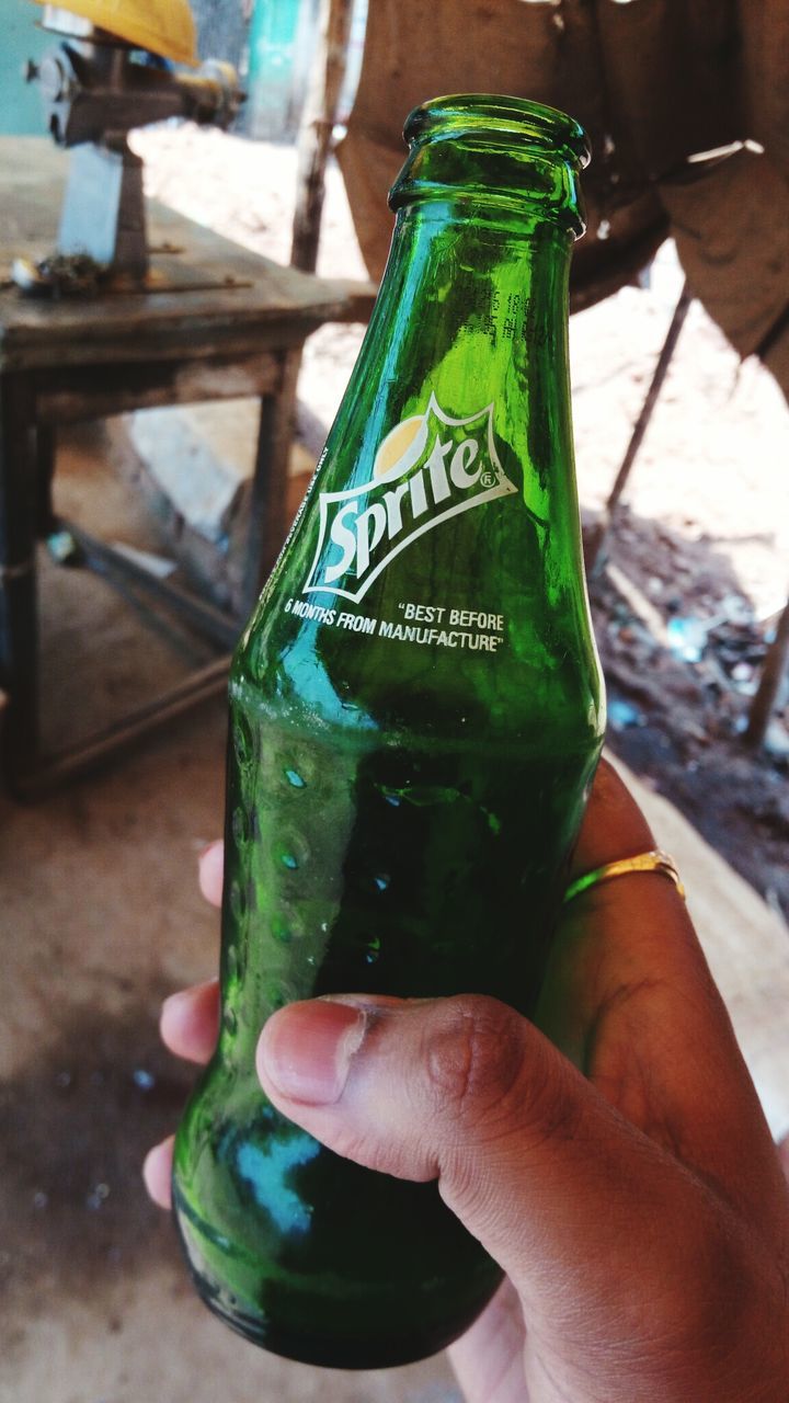 CLOSE-UP OF HAND HOLDING GLASS OF BEER