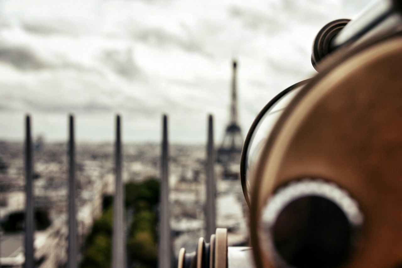 Close-up of cropped coin operated binoculars facing blurred cityscape