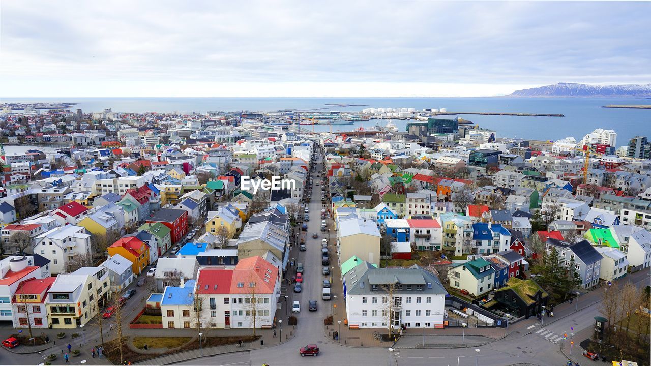 High angle view of townscape by sea against sky