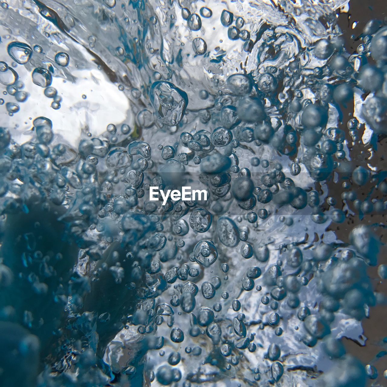 FULL FRAME SHOT OF WATER DROPS ON BLUE SURFACE