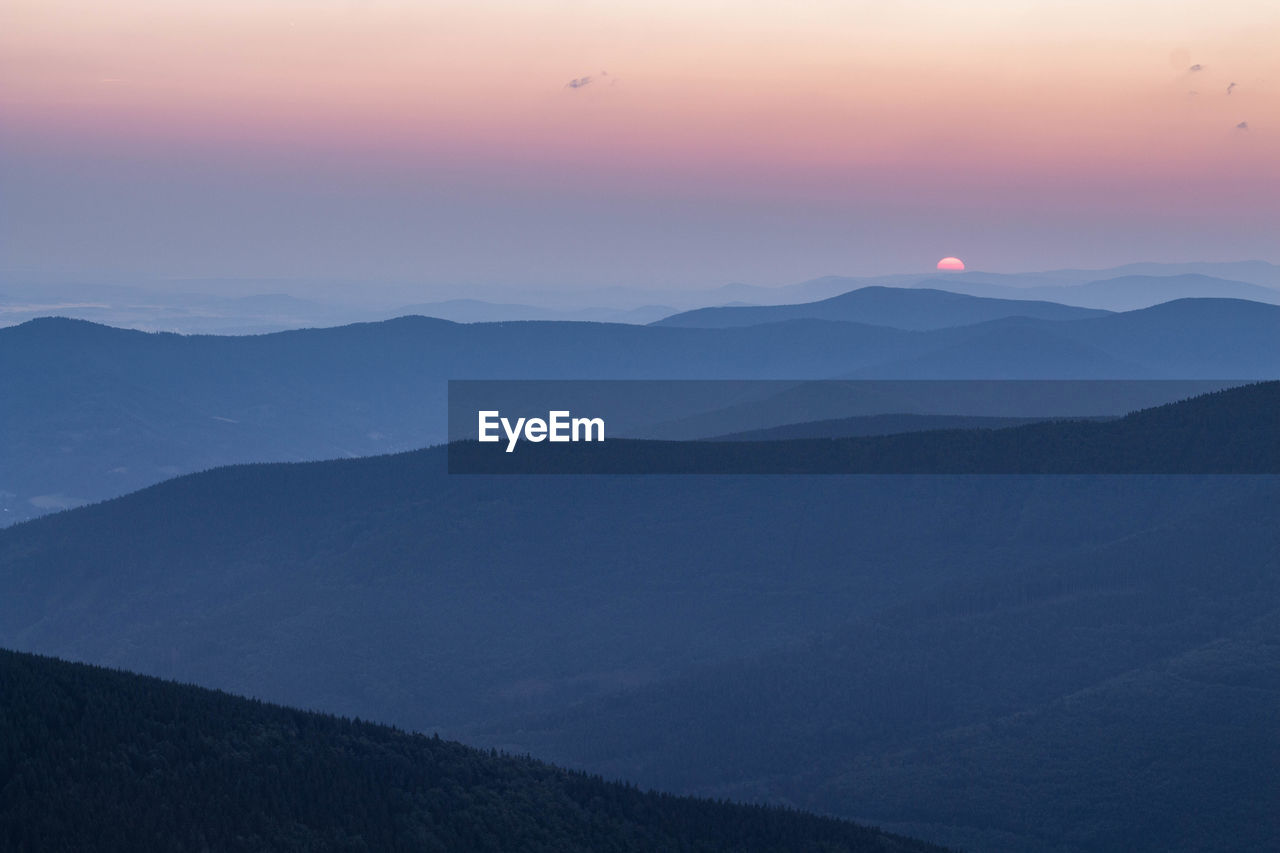 Scenic view of silhouette mountains against sky during sunset