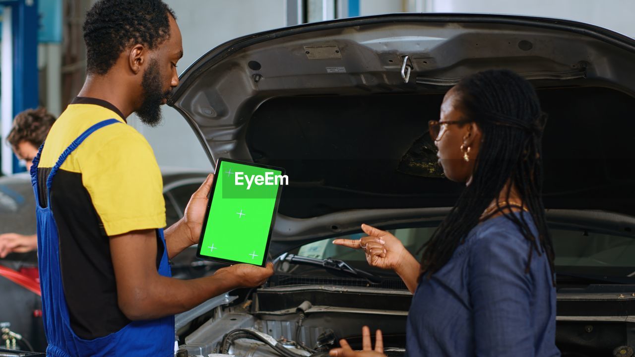 rear view of woman using mobile phone while sitting in car