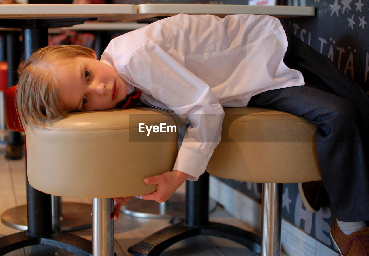 Boy lying on chair