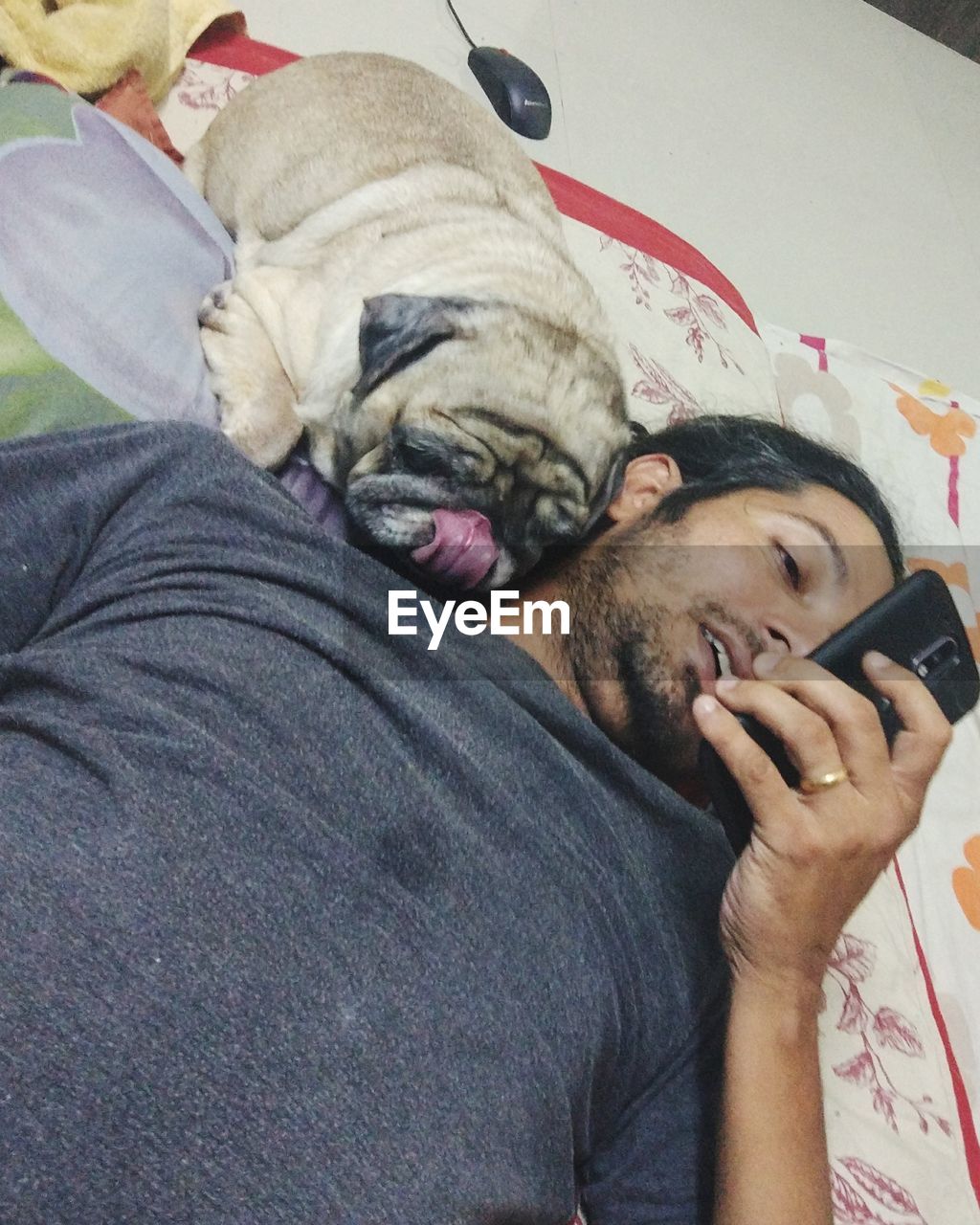 CLOSE-UP OF MAN WITH DOG RELAXING ON BED