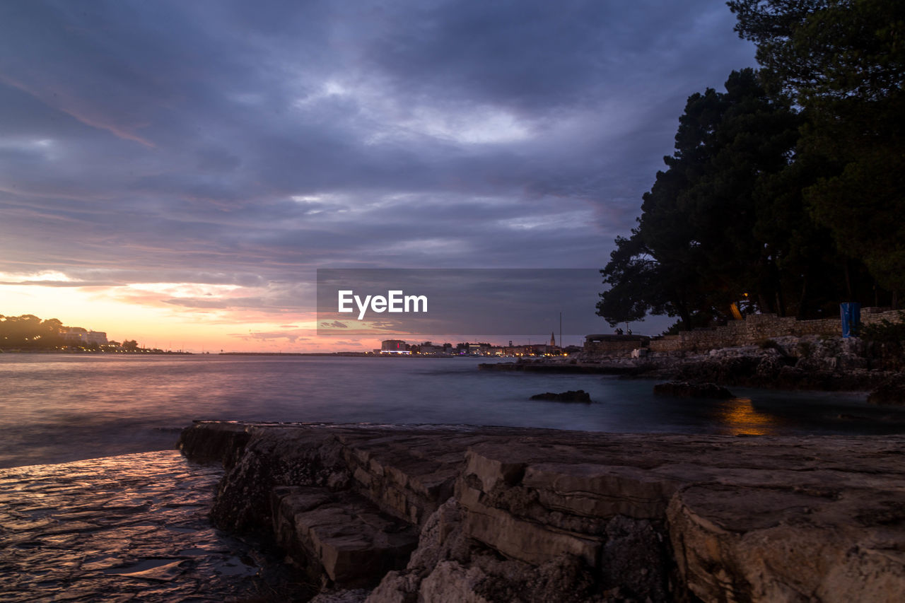 SCENIC VIEW OF BEACH AGAINST SKY DURING SUNSET