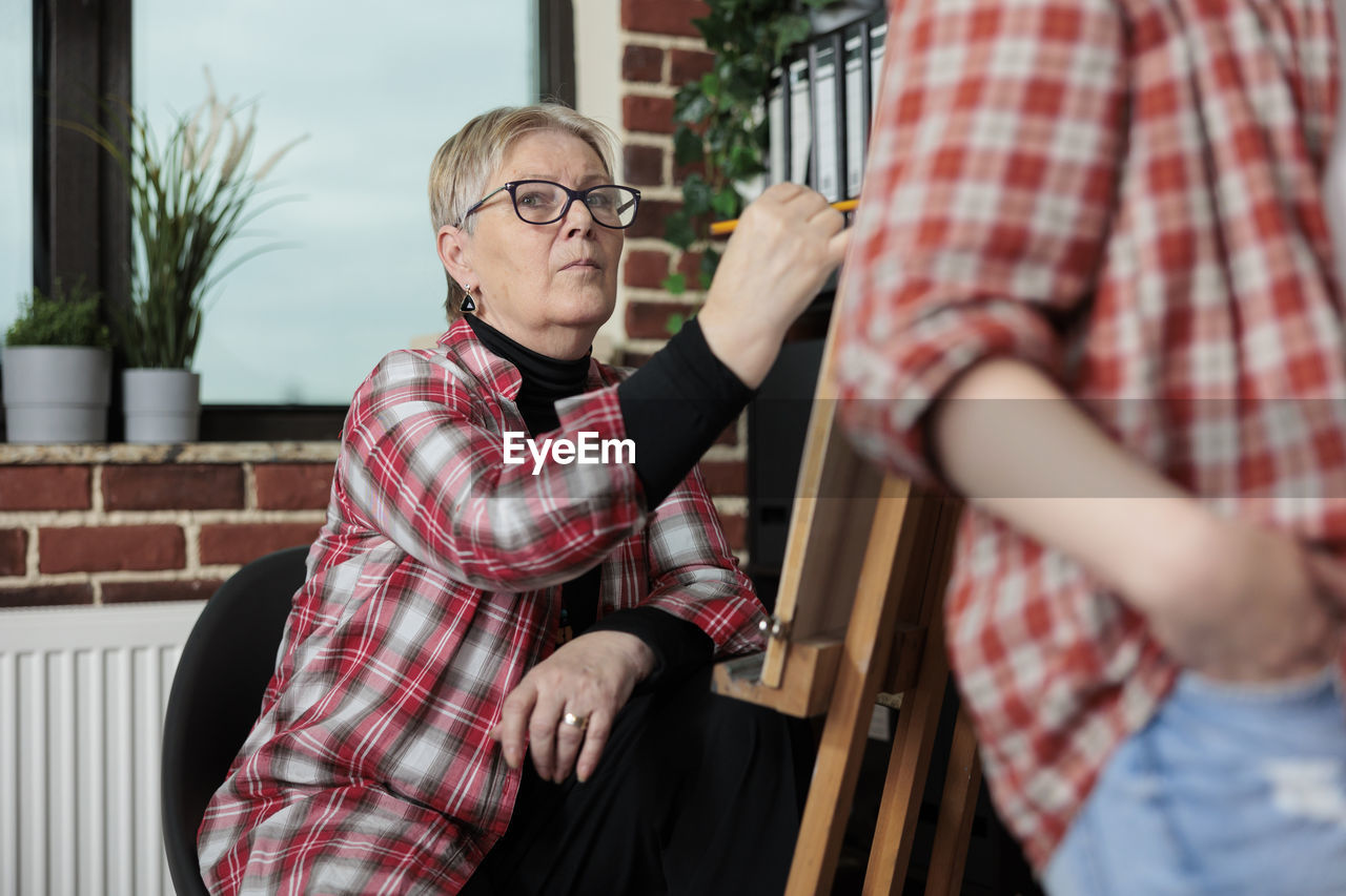 Senior woman practicing during drawing class