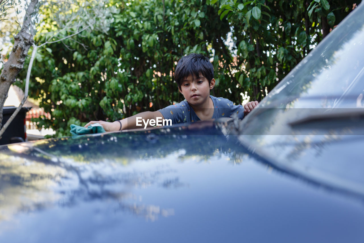 Child washing a car in the garden