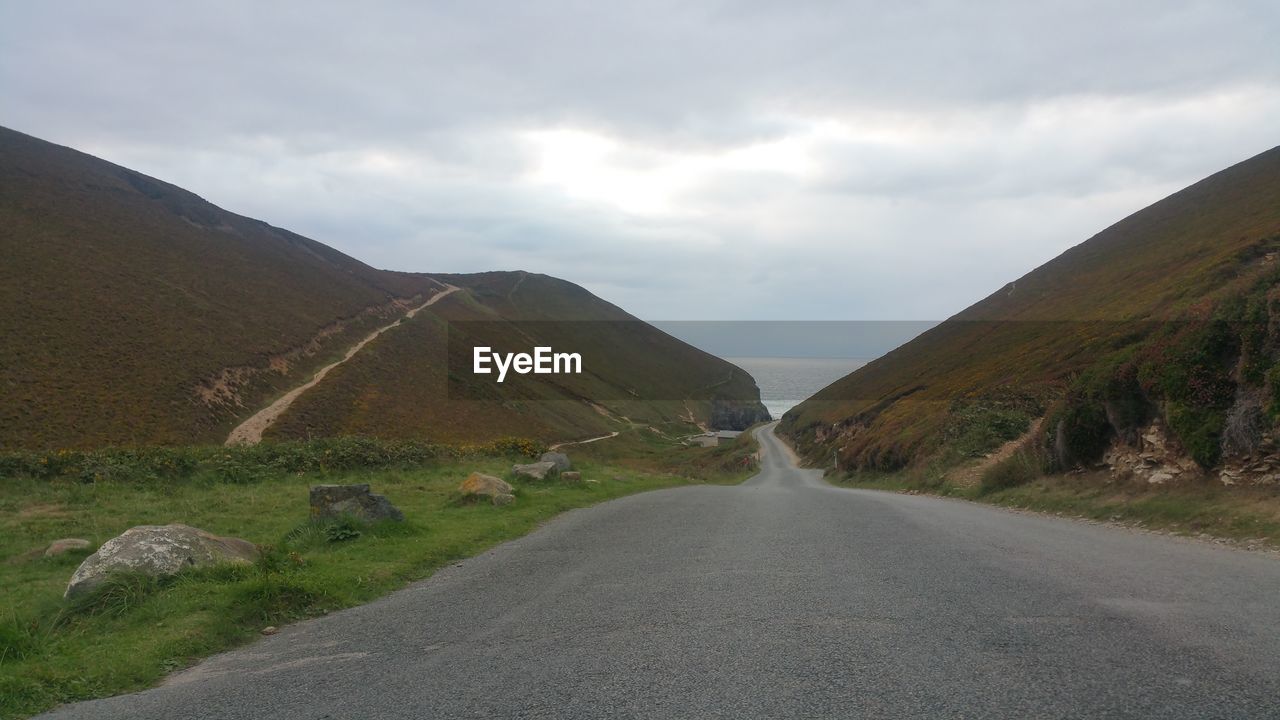 Empty road along countryside landscape