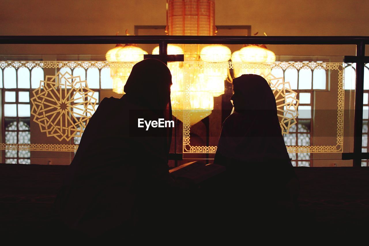 Women wearing hijab sitting in mosque during ramadan