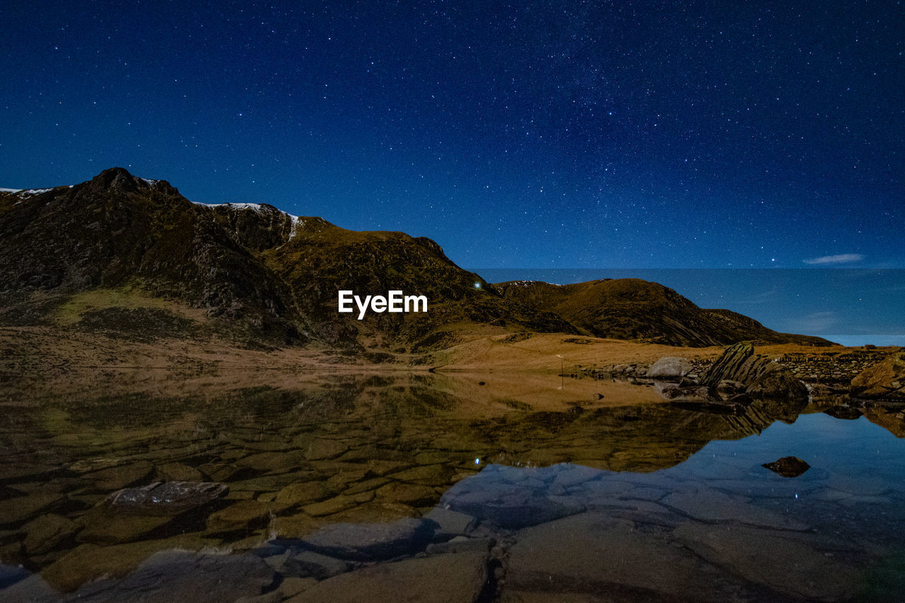 Scenic view of mountains against sky at night