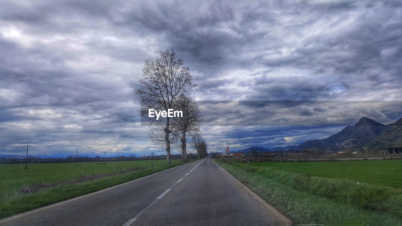 ROAD AMIDST PLANTS ON LAND AGAINST SKY