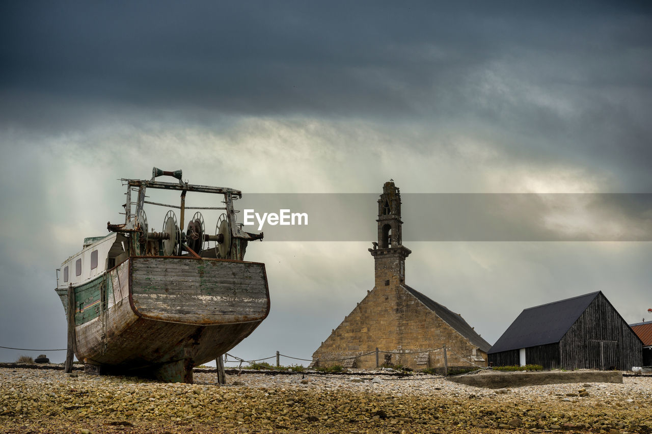 France, brittany, camaret-sur-mer, trawler in ship cemetery with chapelle notre-dame-de-rocamadour in background