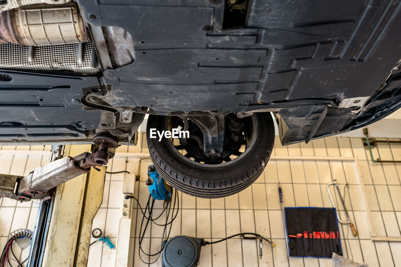 Car chassis on the lift, view from the bottom. visible exhaust system, wheels, brake hoses.