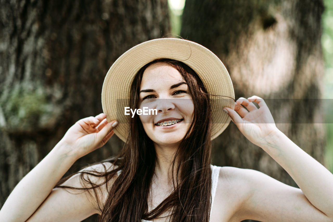 Candid portrait of beautiful happy smiling young woman with braces in summer park. outdoor portrait