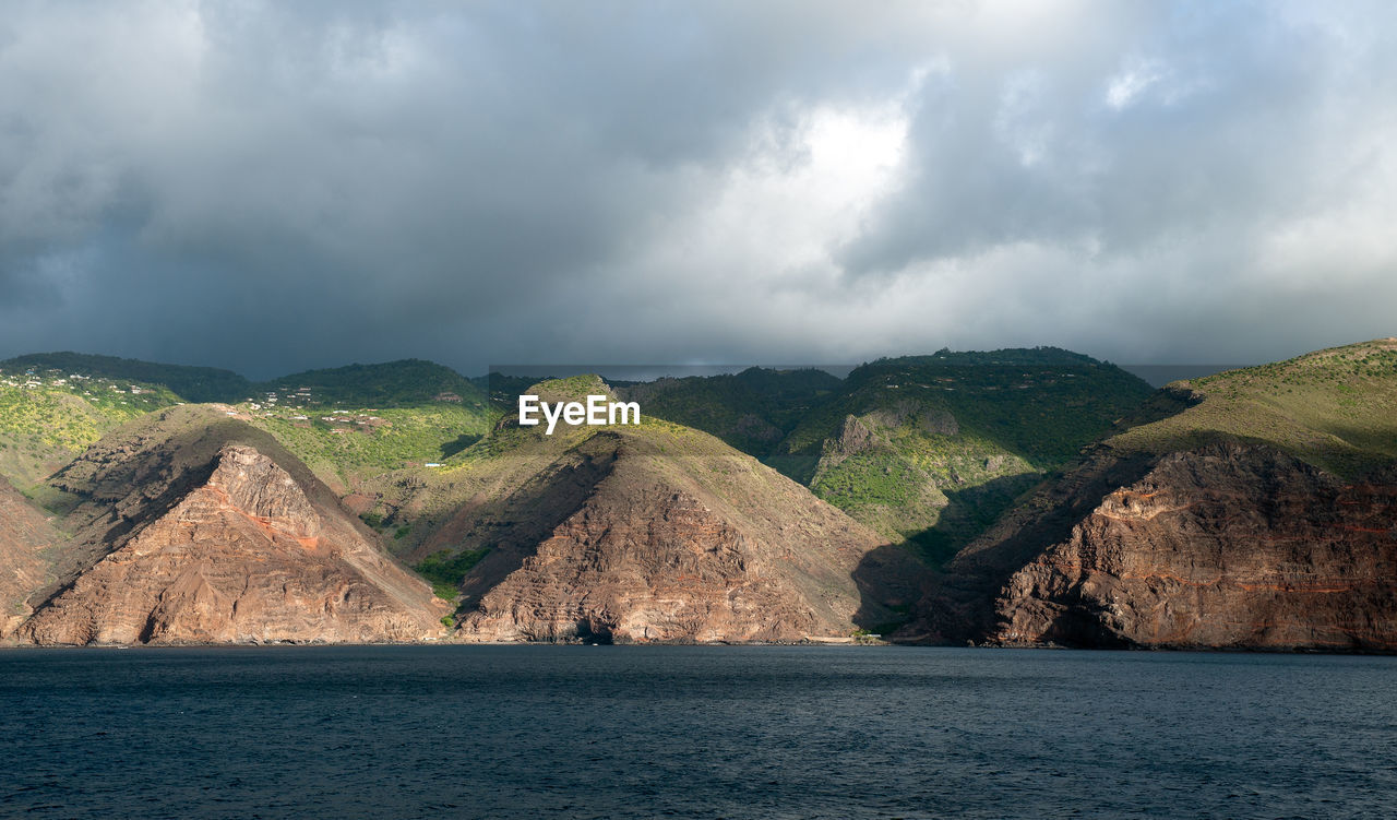 Scenic view of sea and mountains against sky