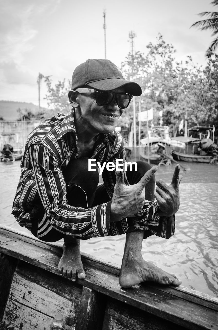 MAN WEARING SUNGLASSES SITTING IN CONTAINER