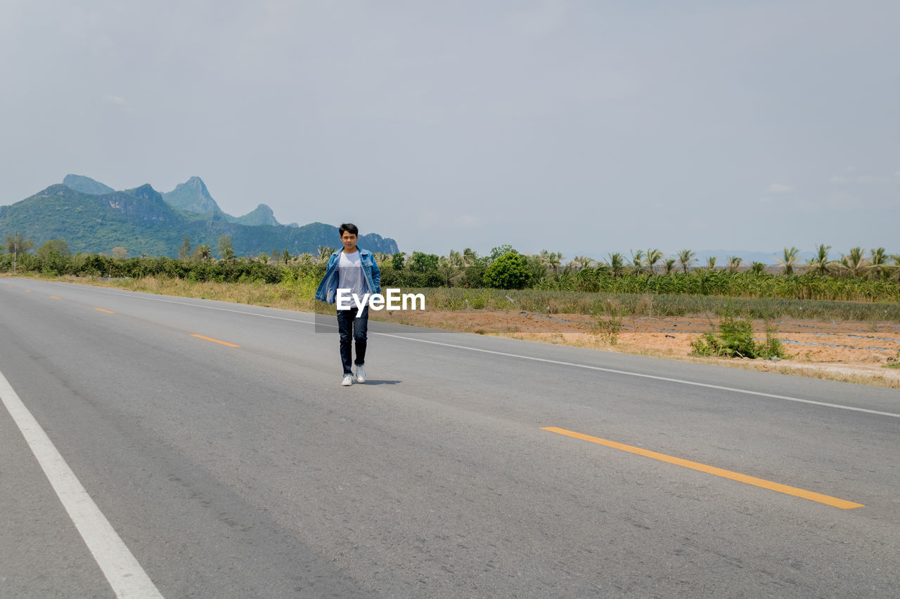 Rear view of man standing on road