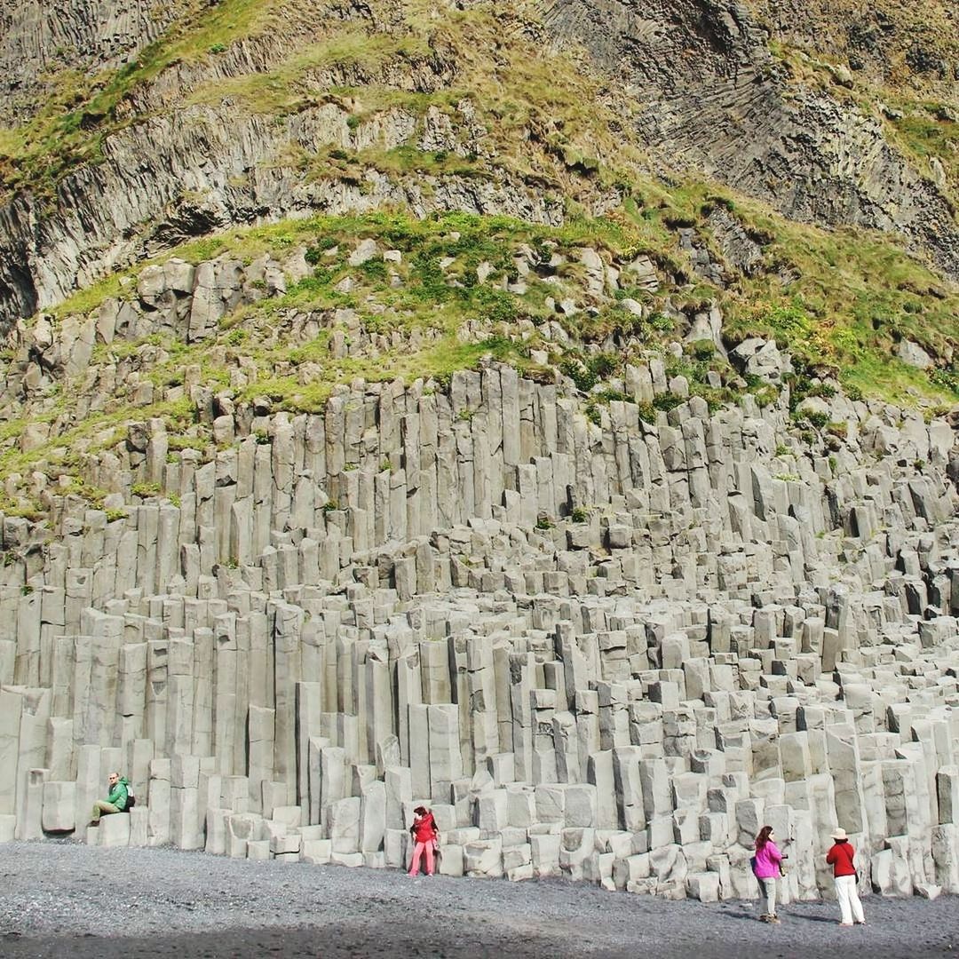 PEOPLE ON ROCKS BY MOUNTAIN