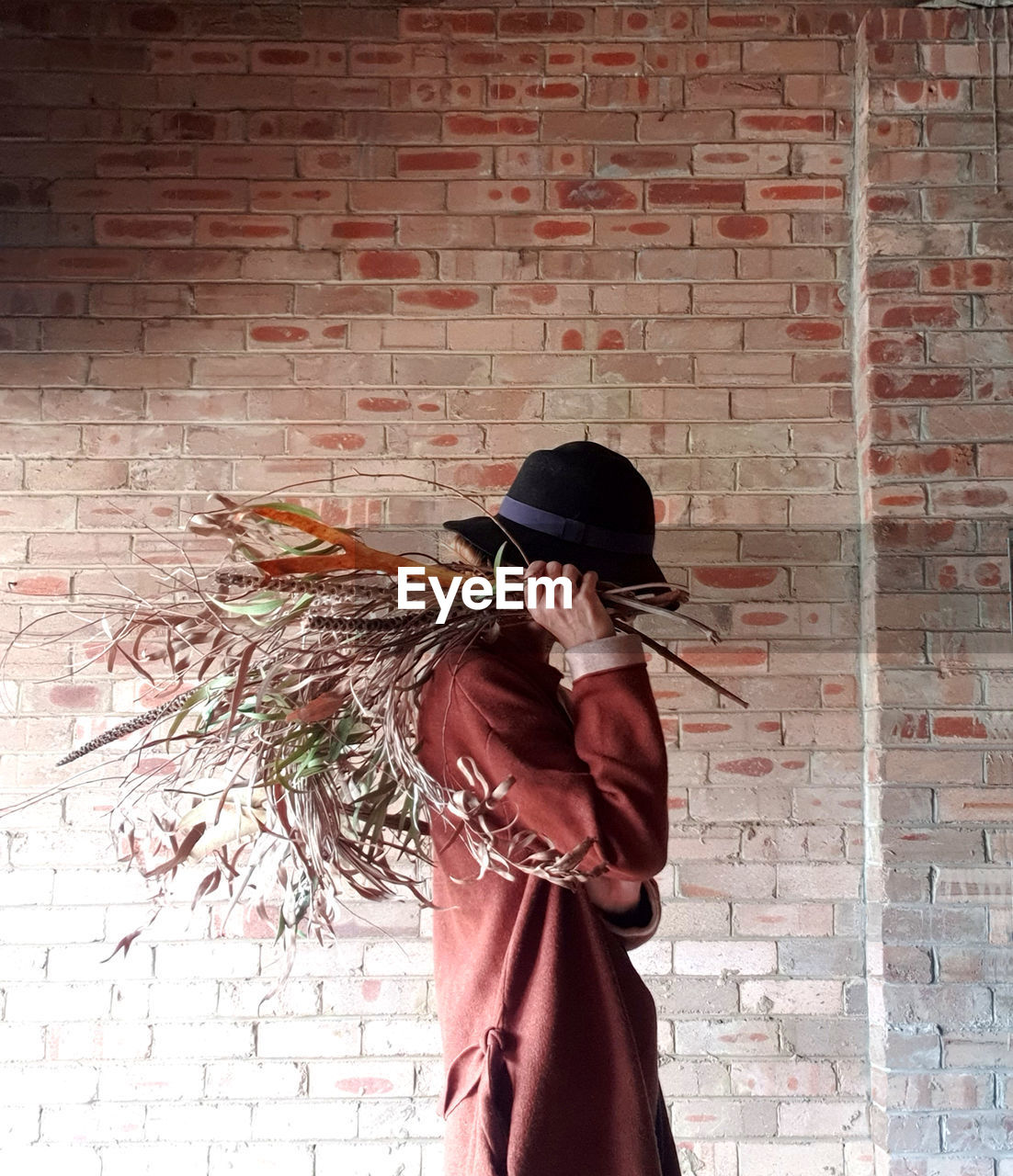 WOMAN STANDING AGAINST WALL