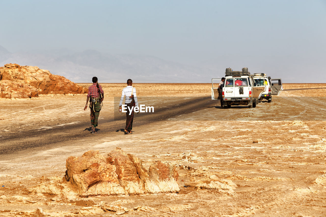 REAR VIEW OF PEOPLE ON DESERT