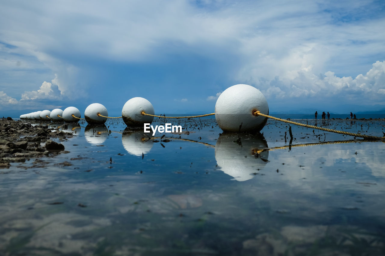 WHITE FLOATING ON WATER AGAINST SEA