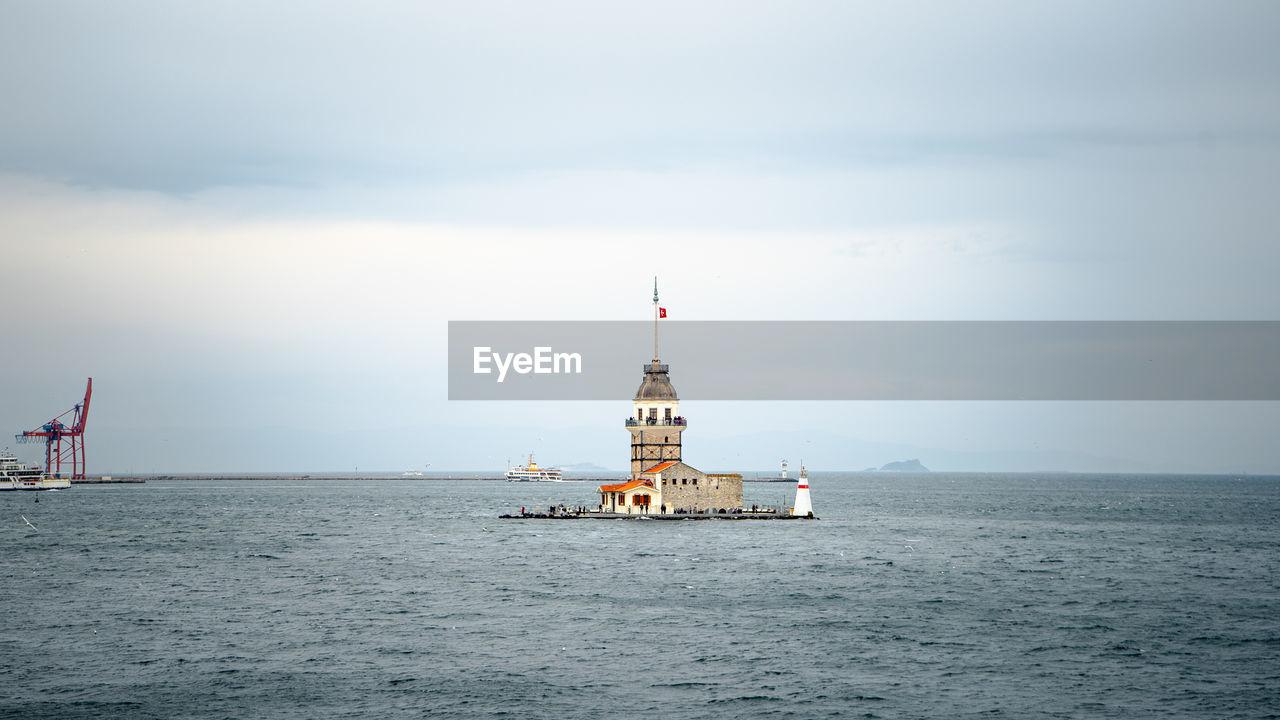 Maiden's tower by sea against sky