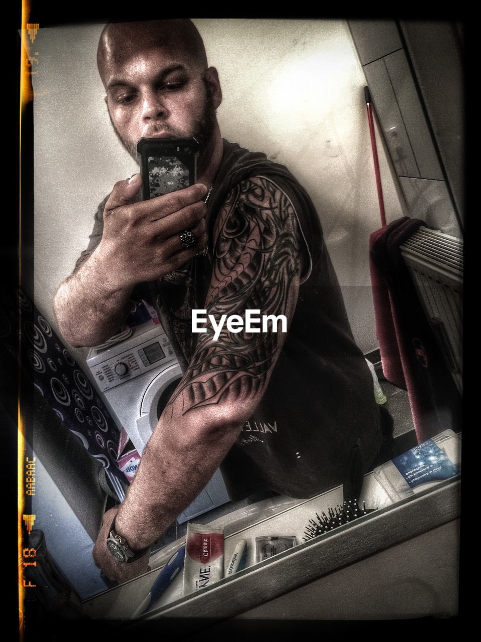 Man taking selfie showing off tattoo