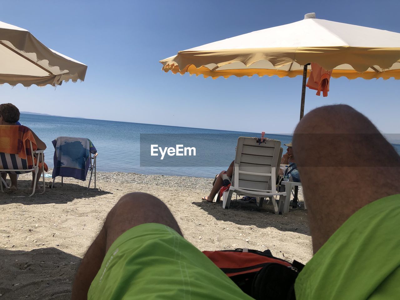 LOW SECTION OF MAN RELAXING ON BEACH