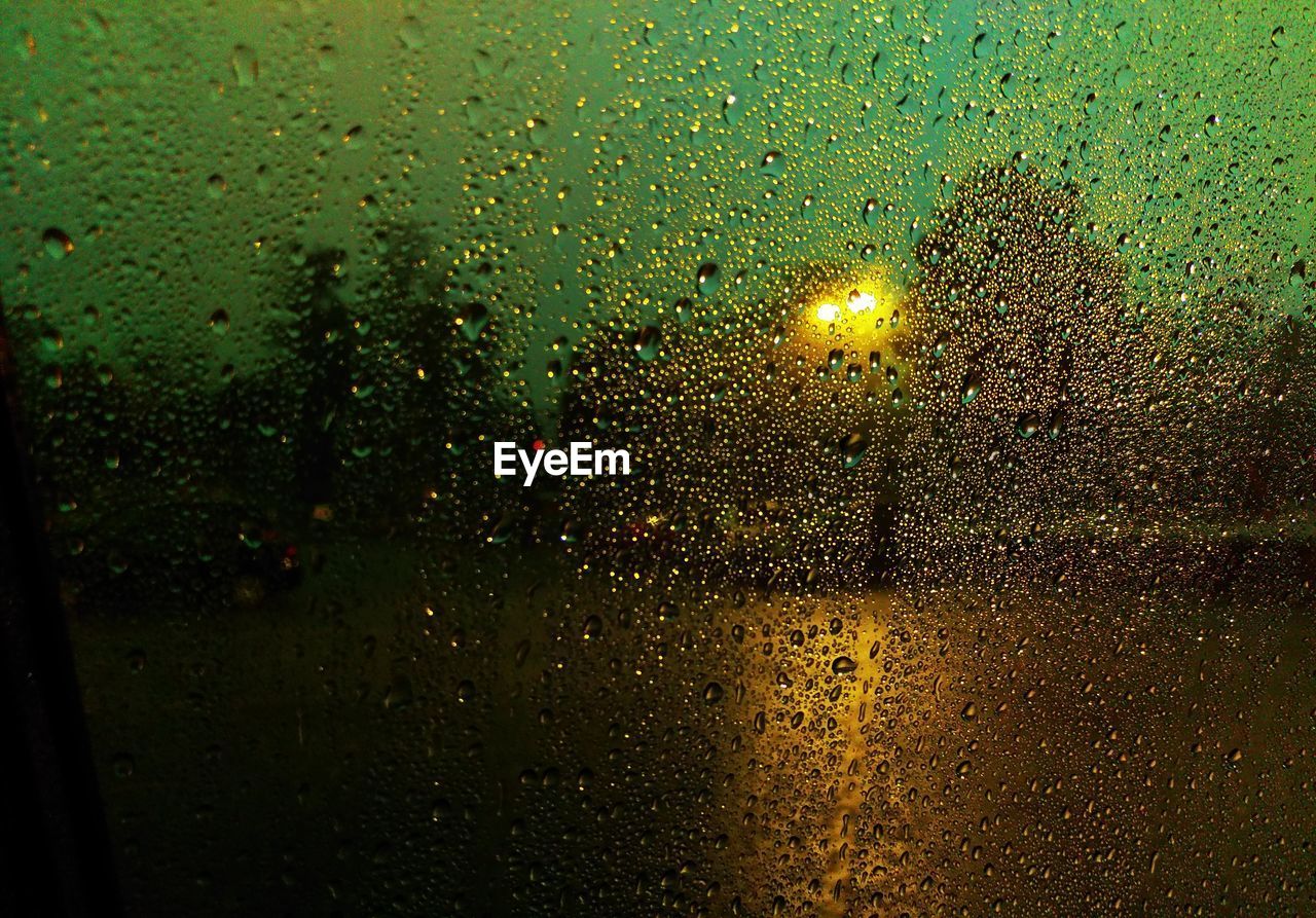 Full frame shot of glass covered with raindrops