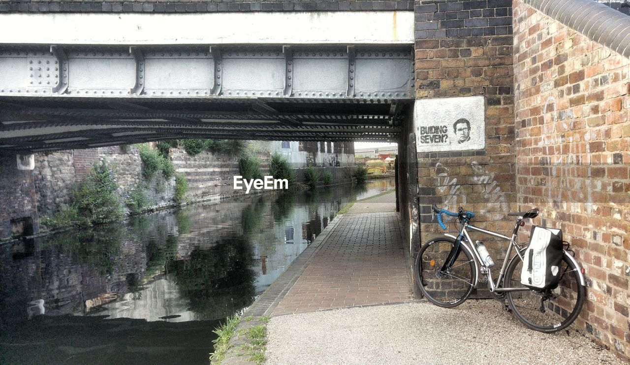 BICYCLE PARKED BY BRIDGE