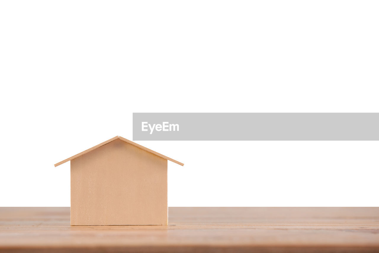 Close-up of model home on table against white background