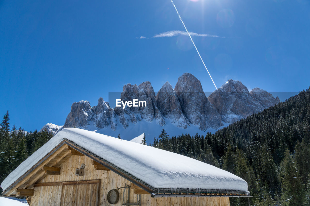 Low angle view of snowcapped mountain against blue sky