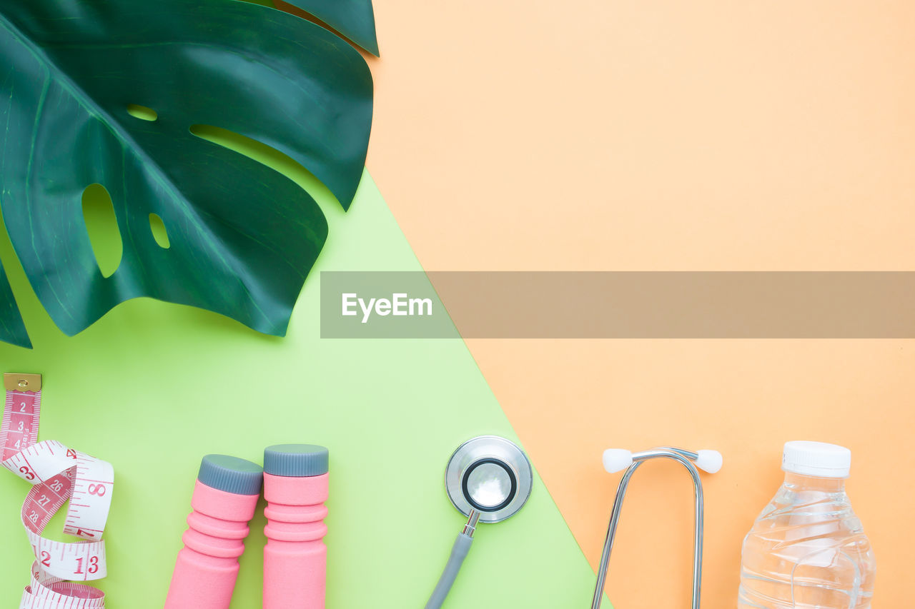 Directly above shot of leaf with medical and sports equipment on table