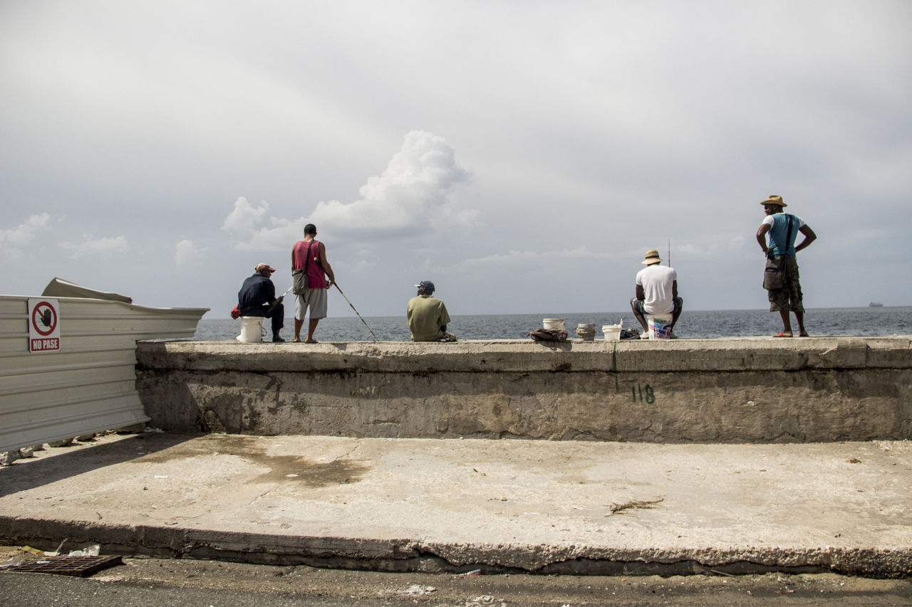 PEOPLE ON SHORE AGAINST SKY