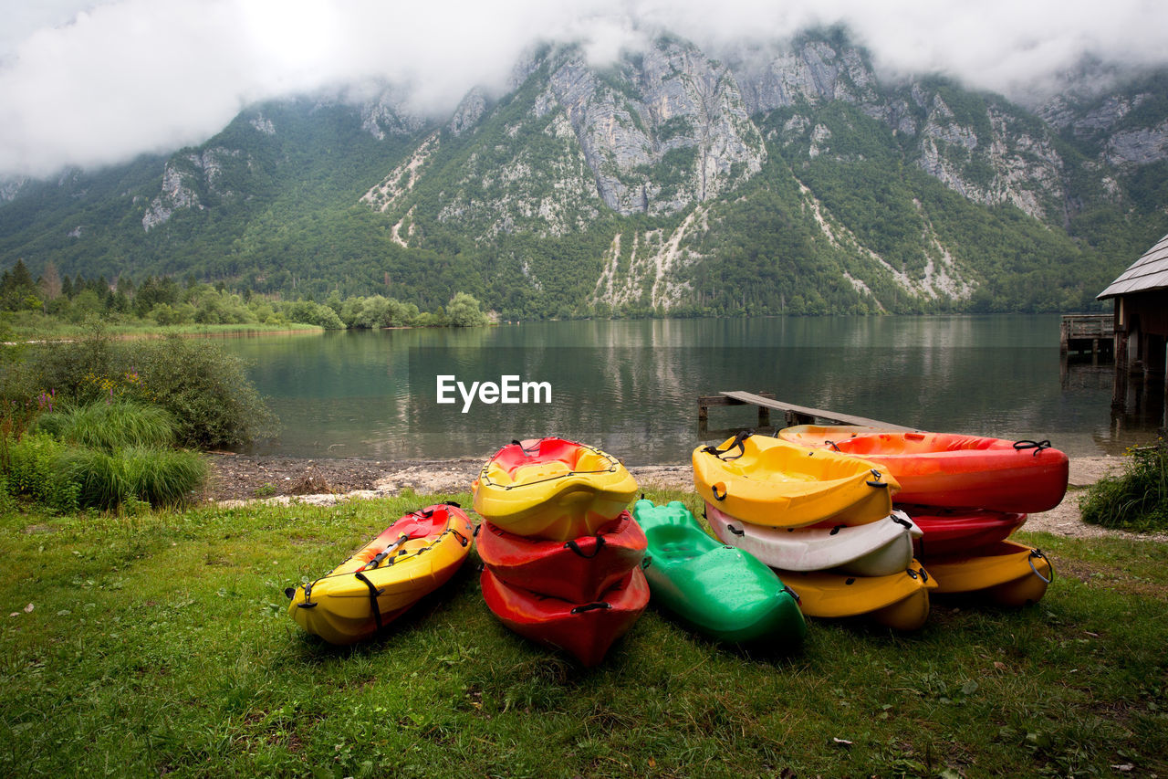 Boats moored at lakeshore against mountains