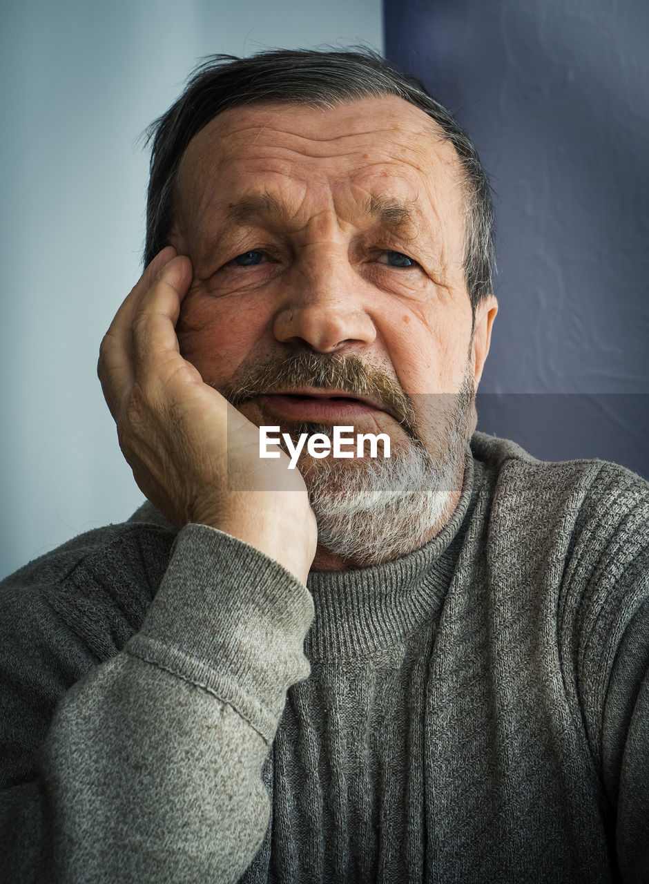 Close-up portrait of sad man at home