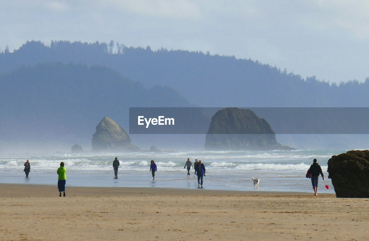 People at beach with rock formations