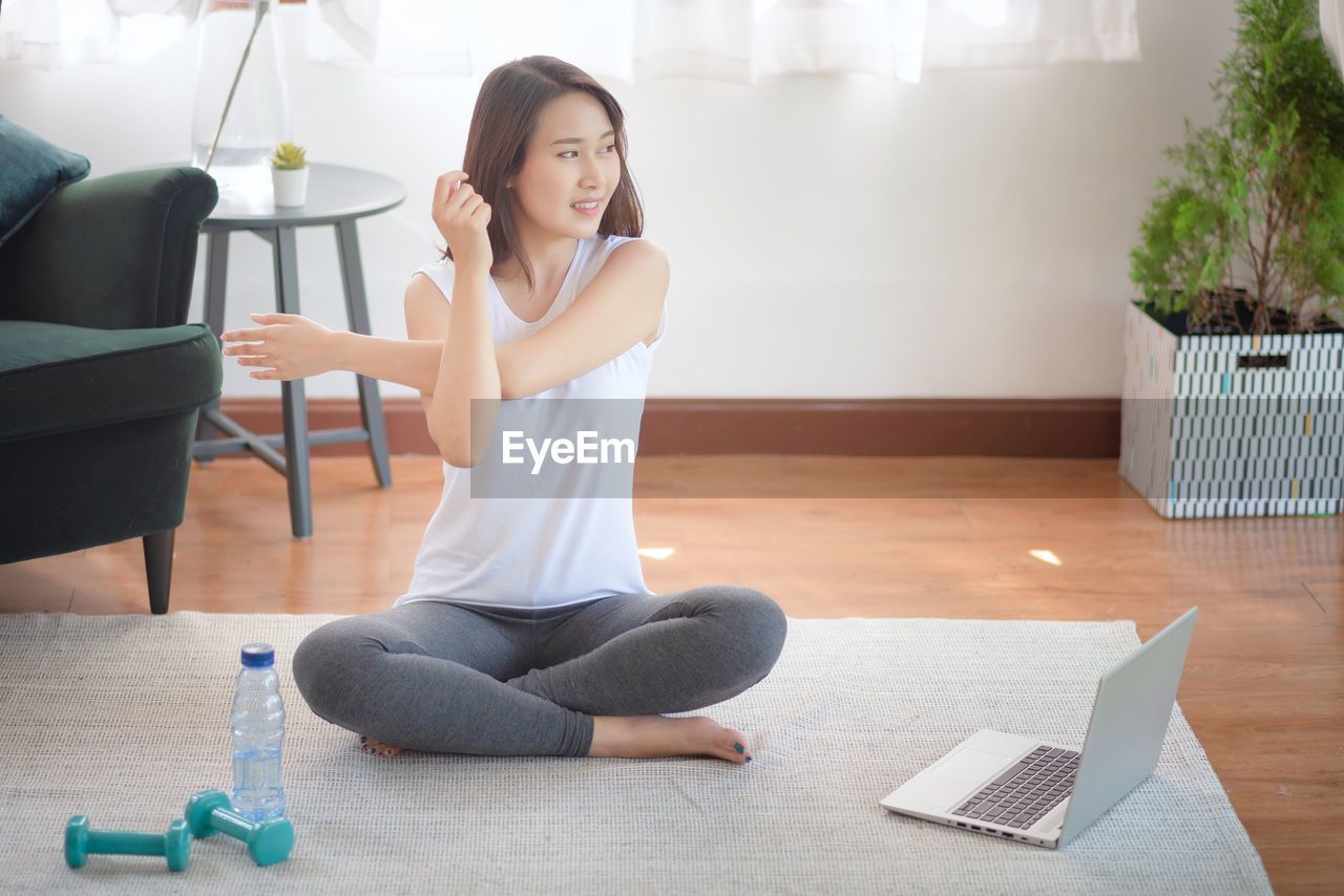 Beautiful asian woman staying fit by exercising at home for healthy trend lifestyle