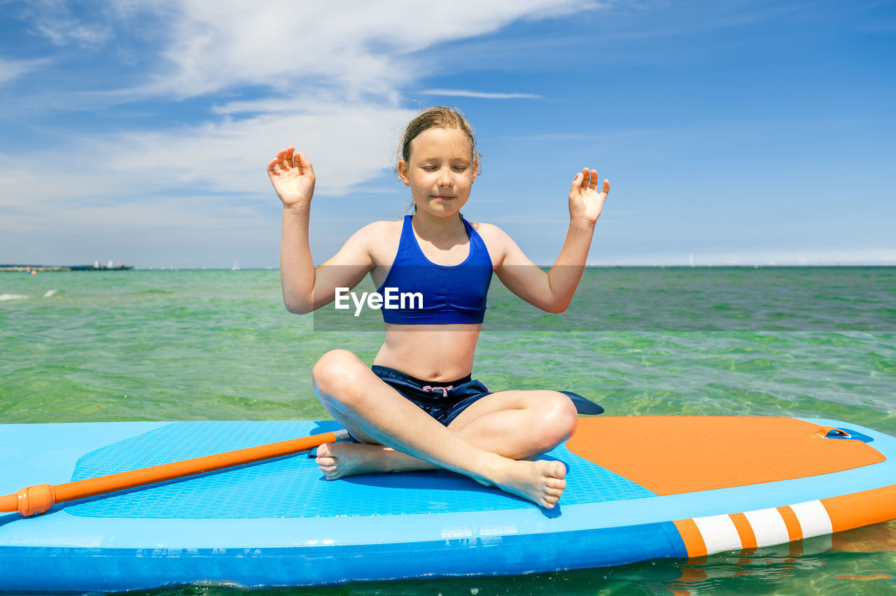 Full length of woman smiling against sea