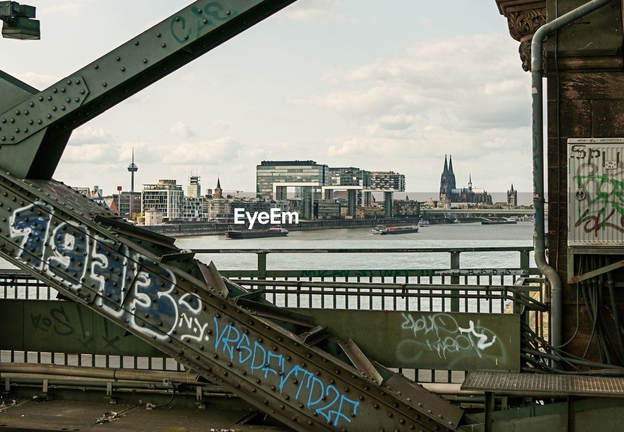 Bridge over river by buildings in city against sky cologne kranhäuser 