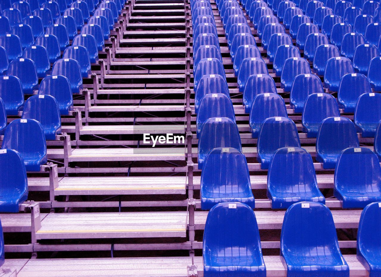 Blue empty chairs arranging in stadium